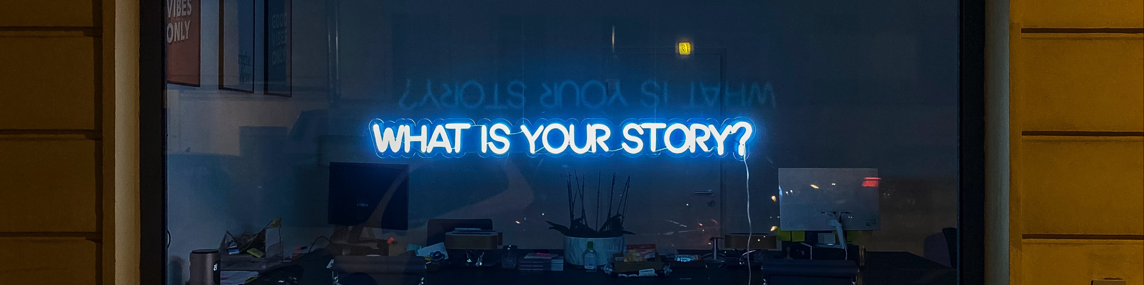 Neon 'What Is Your Story' sign in window storefront