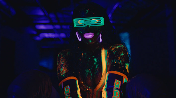 WWE commercial still of woman dancing with neon paint