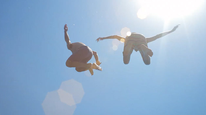Corona commercial still of two friends jumping to the water