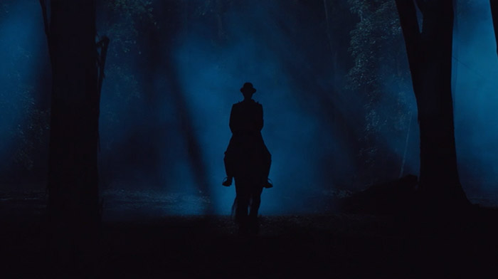 Warsteiner commercial still of men with a hat ridding a horse in the woods during a foggy night