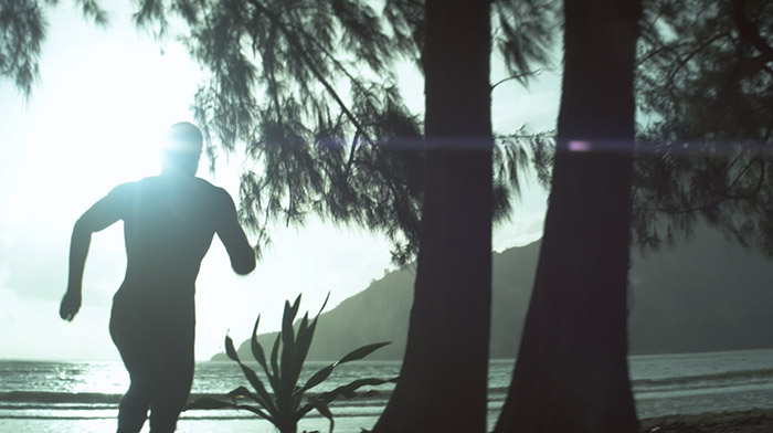 Ark commercial still of a muscular man running in the beach
