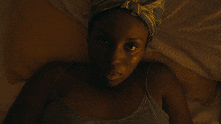 Further Away short film still of a black young woman lying in bed looking straight into the camera