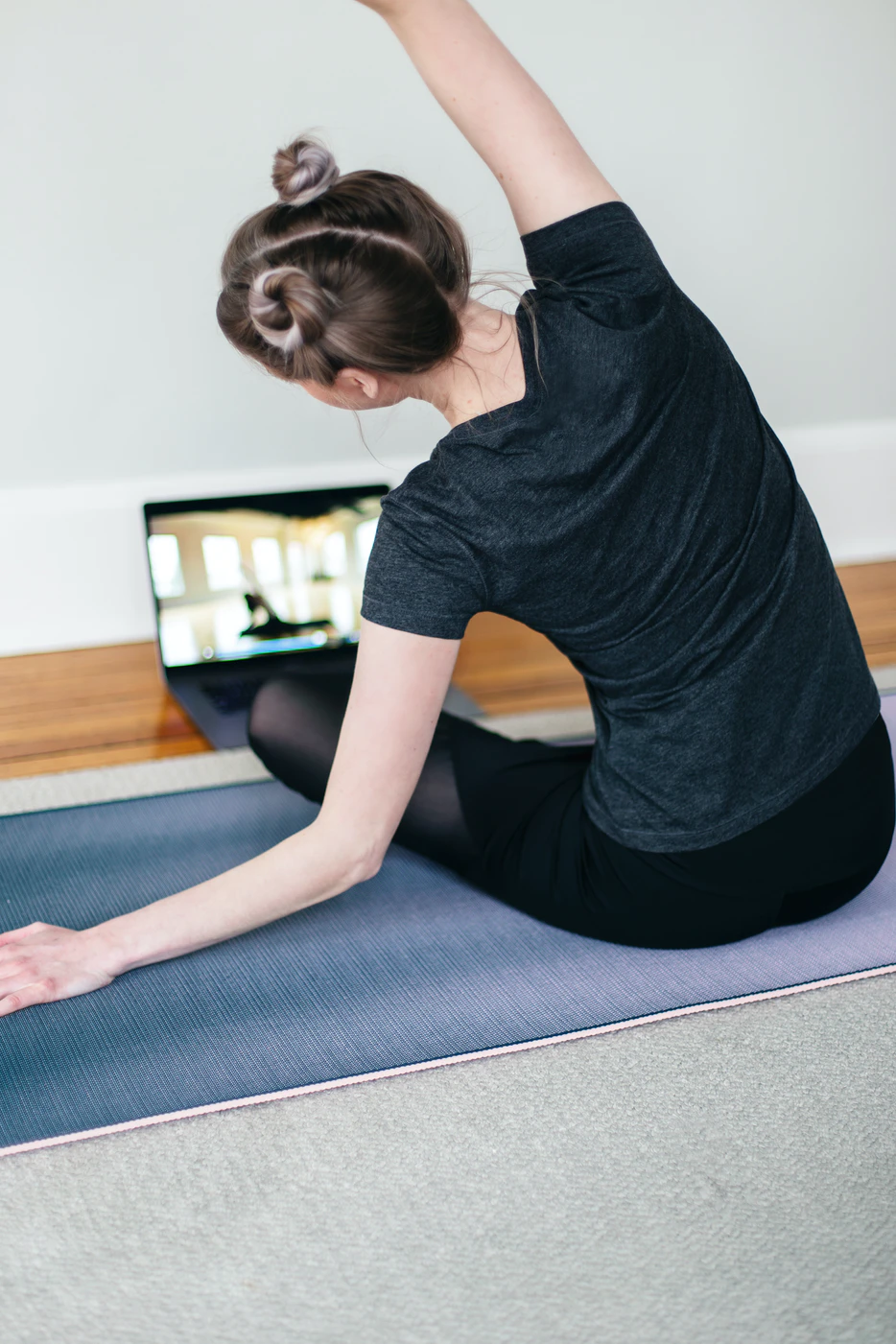 Young woman fitness instructor teaches a virtual fitness class from her home.