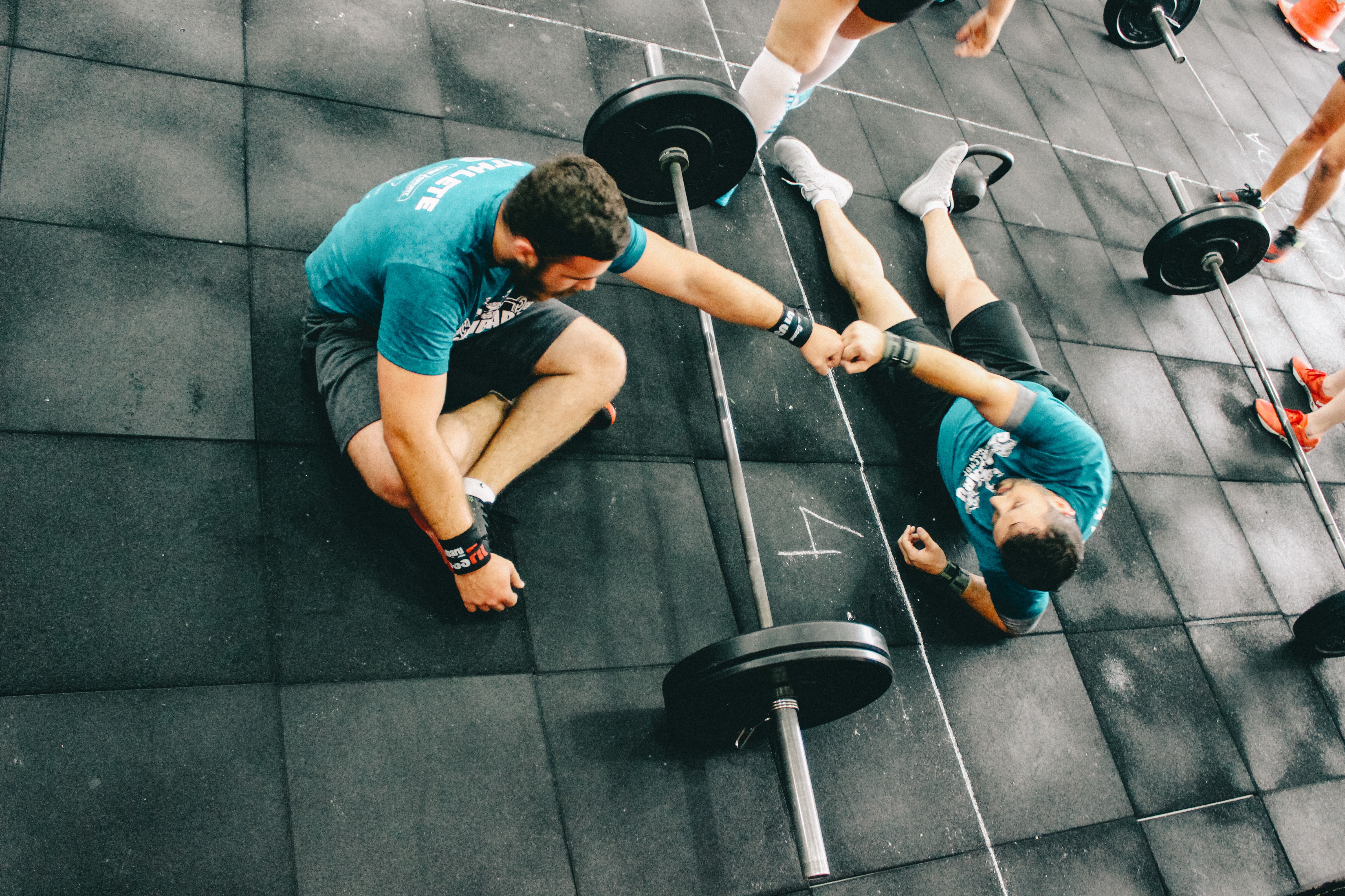 A fitness coach fist bumps his client after completing a workout.