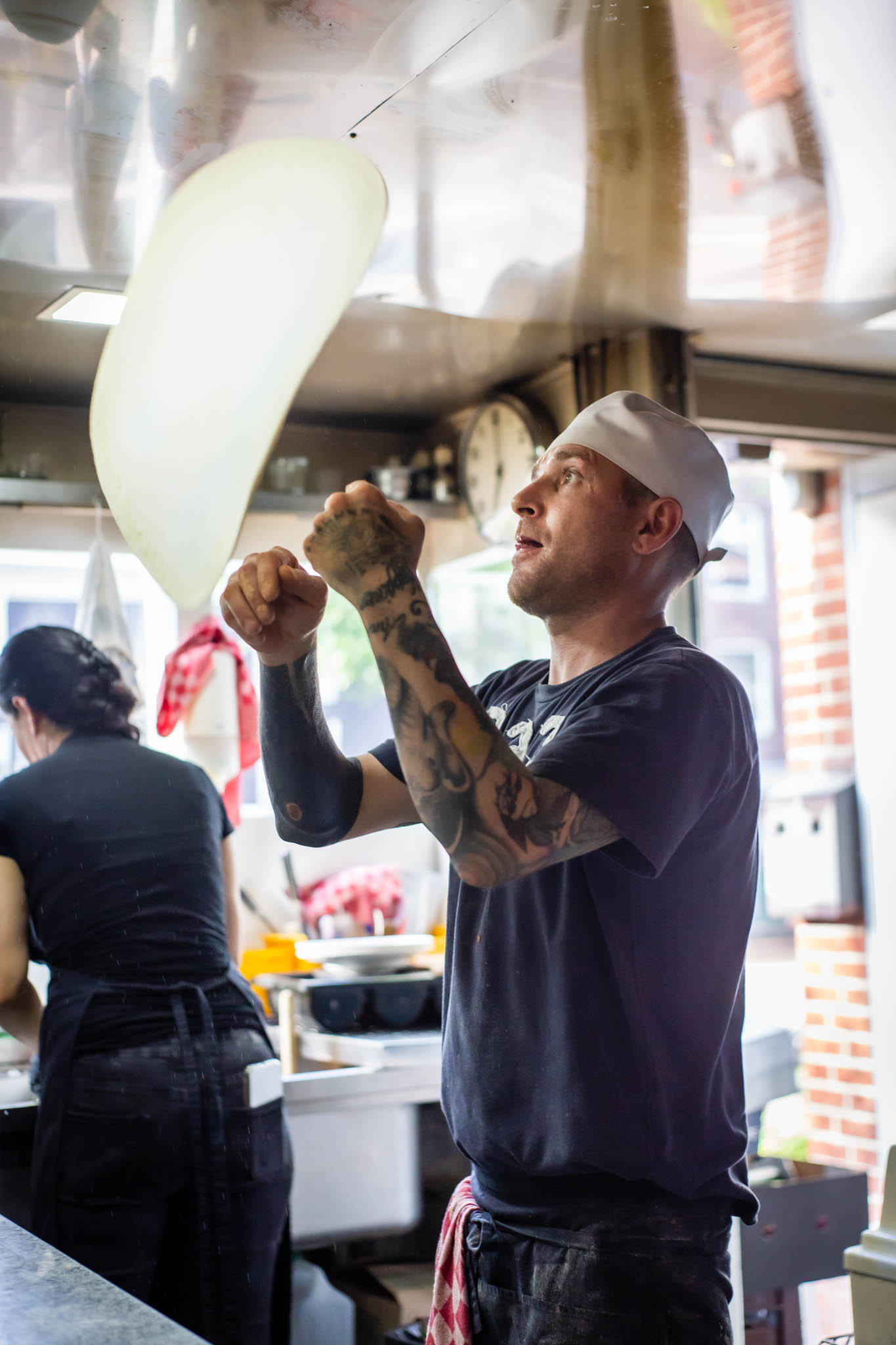 Pizzaiolo throwing pizza to the air in a Italian restaurant