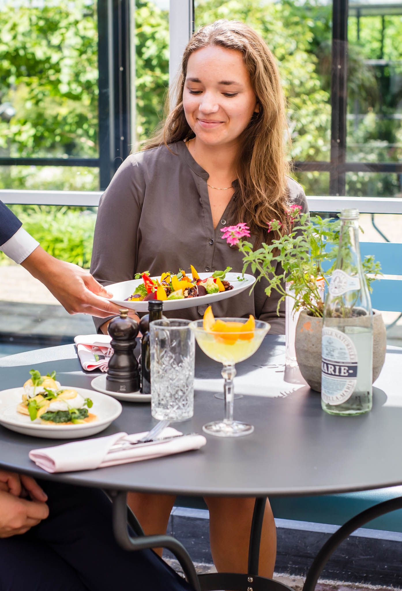 Waitress serving food to a young woman in a restaurant