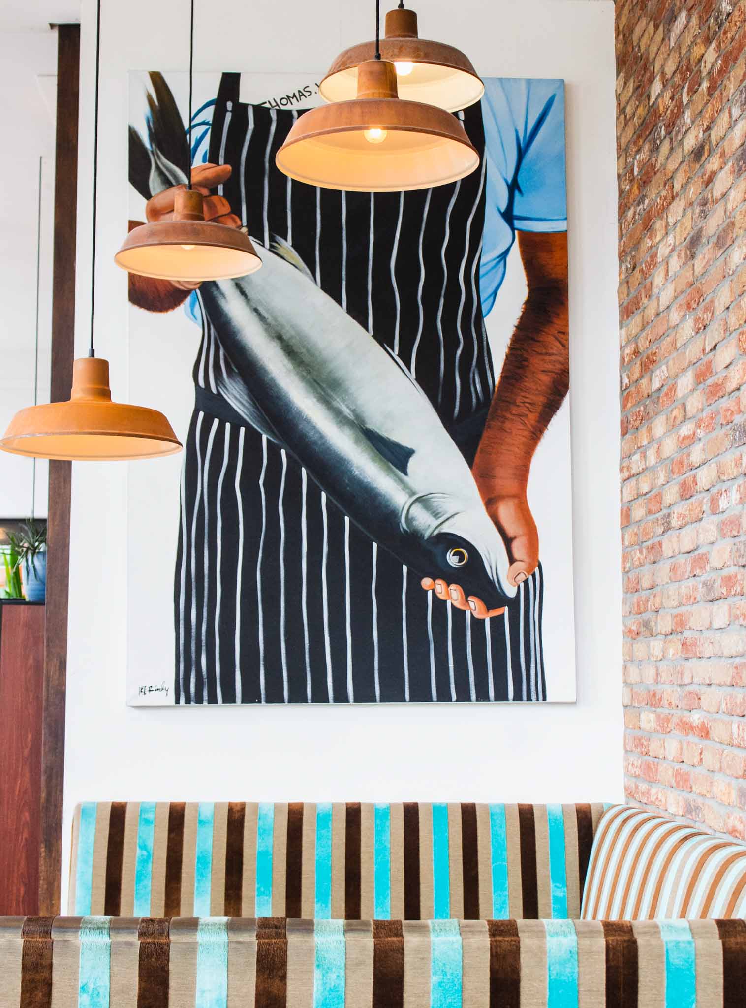Frame of a man holding a fish on the wall of a Mediterranean restaurant