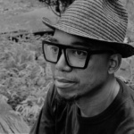 Headshot of Tarish Pipkins in black and white wearing a hat
