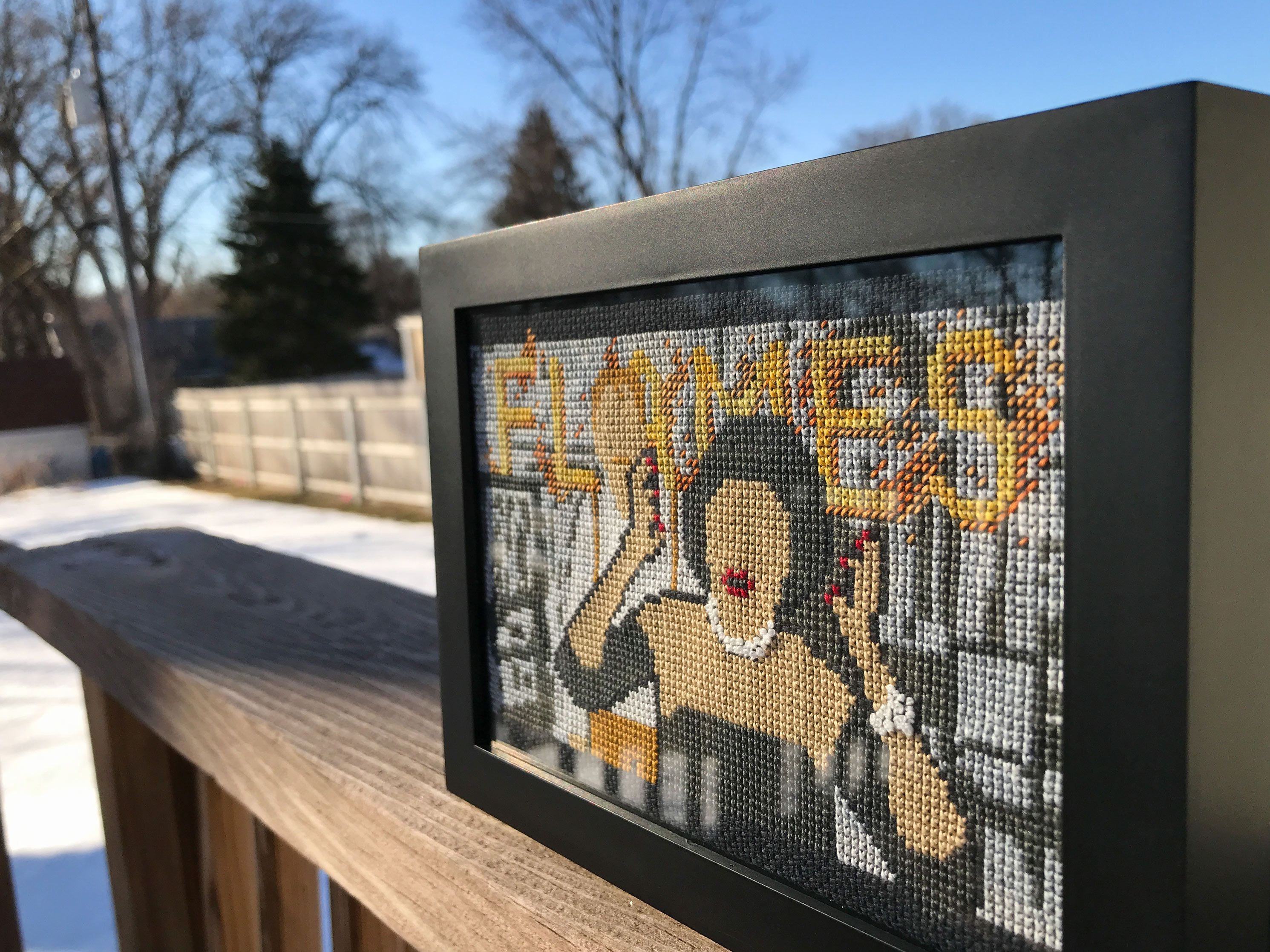 Framed cross stitch depicting scene from 1985 film Clue