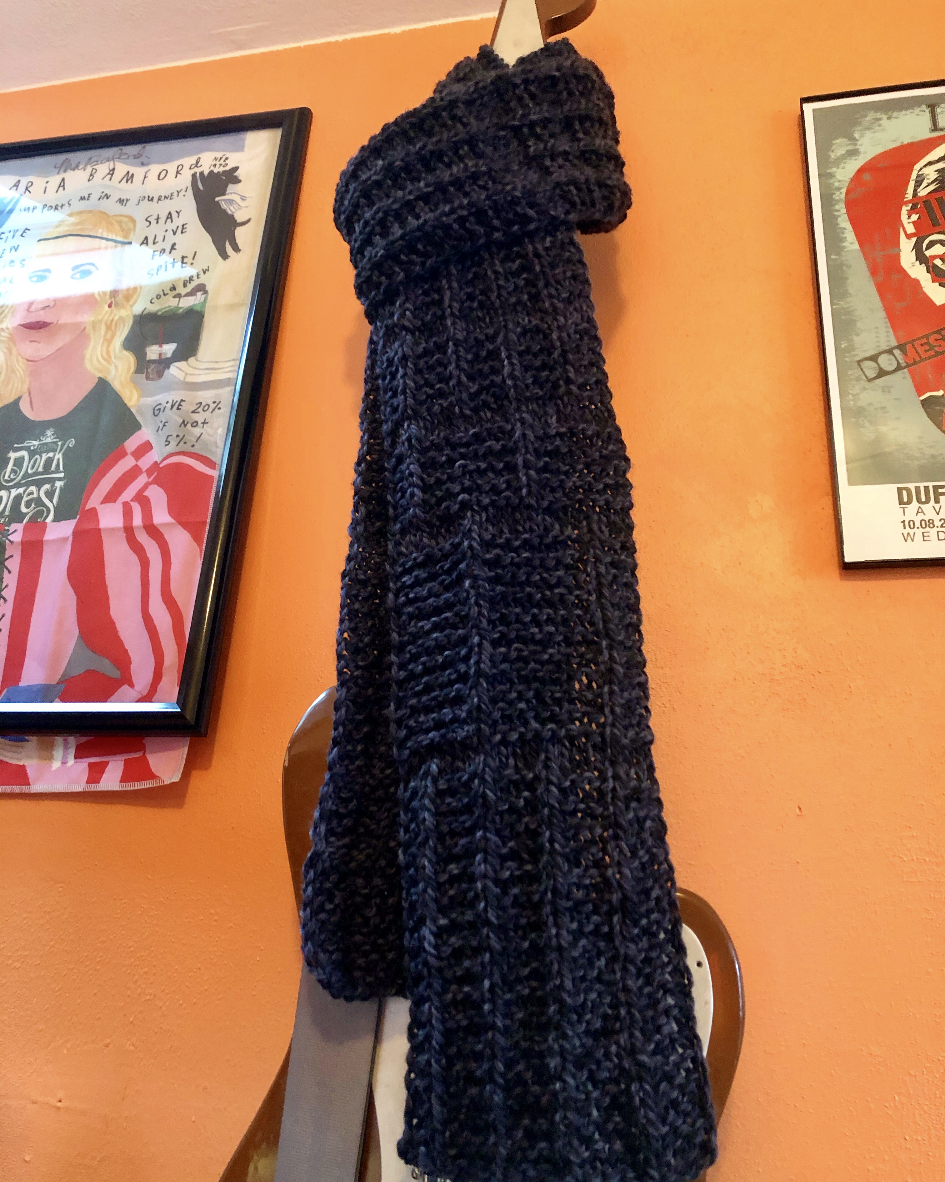 Chunky-knit scarf in dark charcoal, modeled by bass guitar
