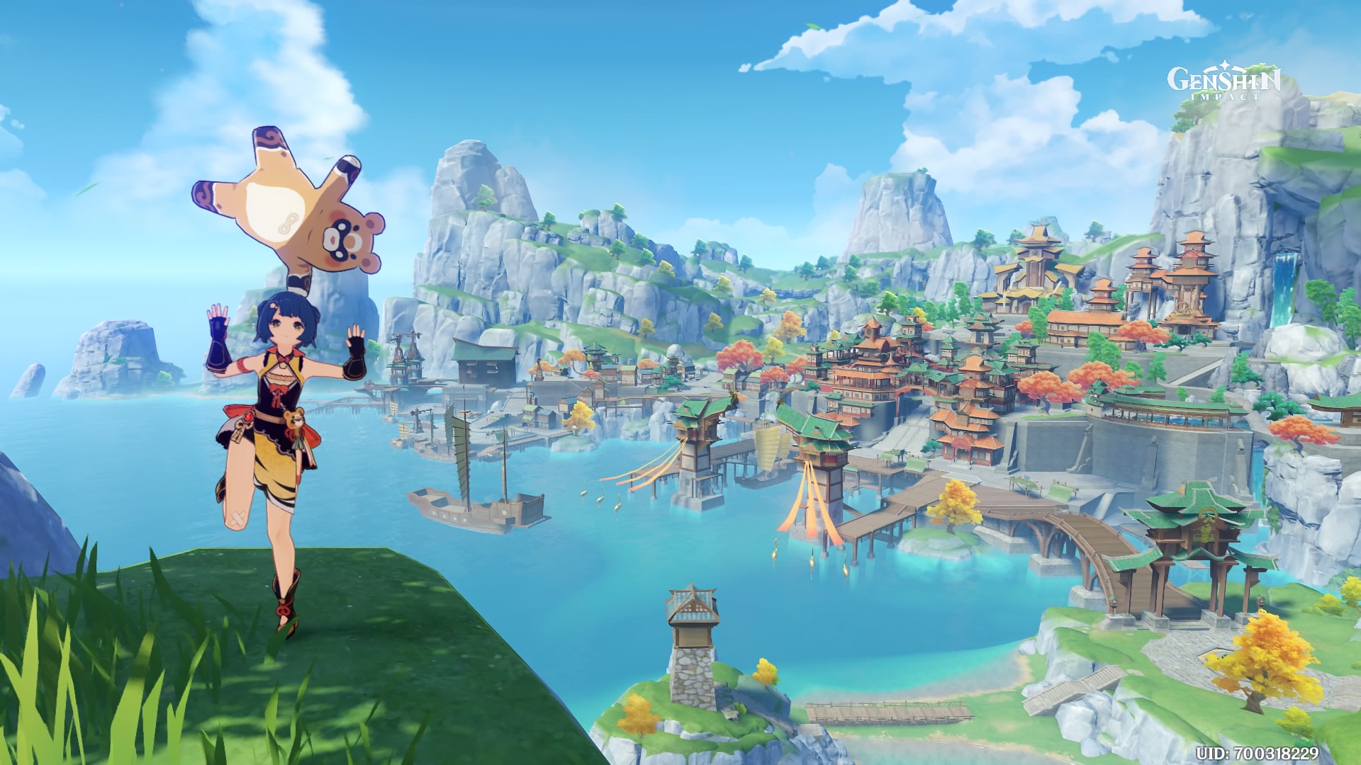 A screenshot of Xiangling with her bear sidekick balanced on her head, Liyue in the background.
