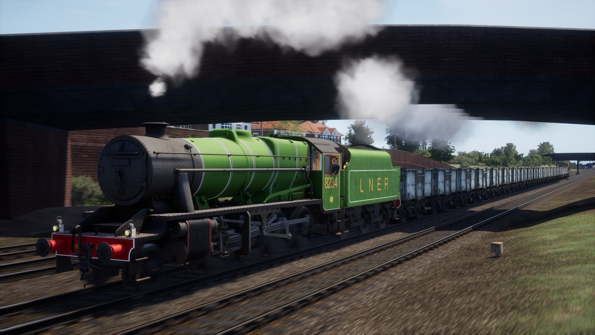 A Stanier 8F resplendent in LNER green livery pulls a rake of trucks.