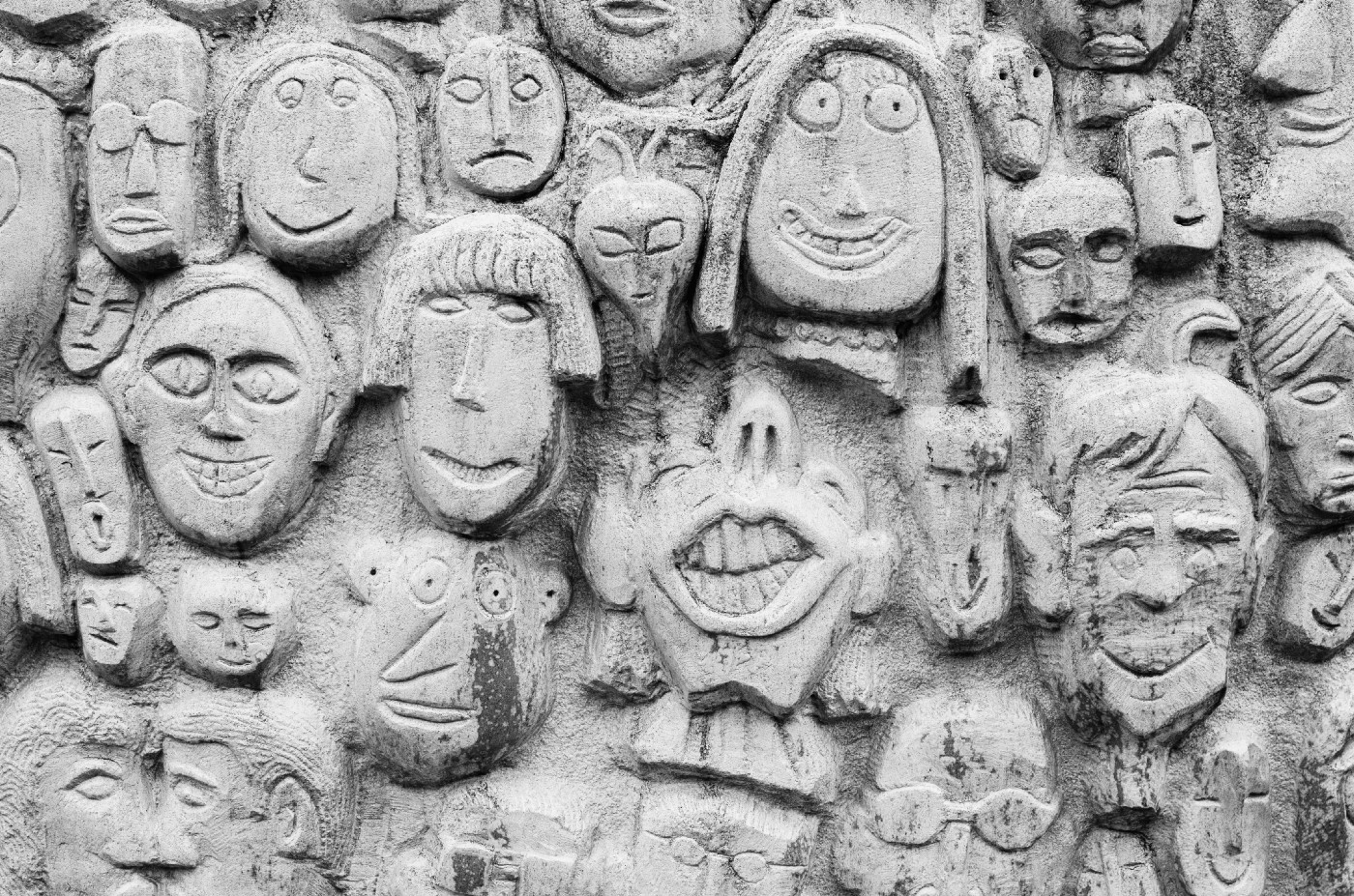 Funny Faces Carved On Cement Wall