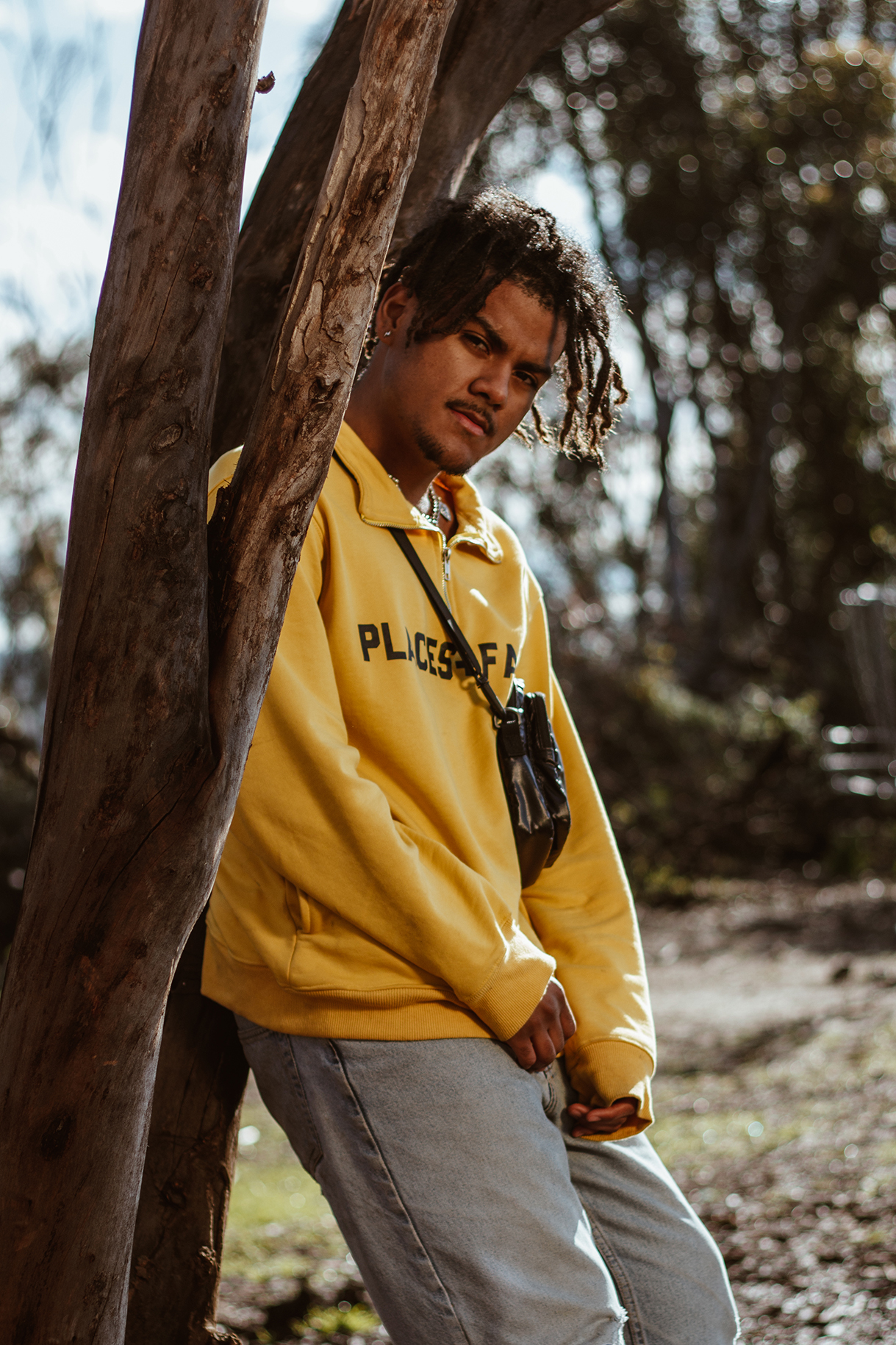 Troi Blank leans on tree staring into camera.