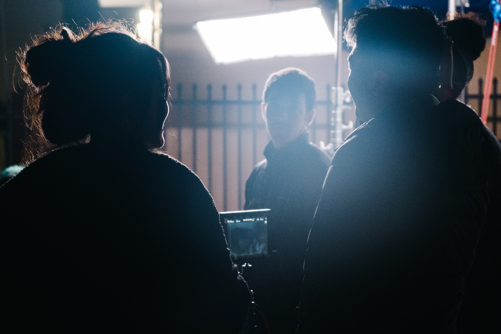 Three people talking to each other at a film set. 