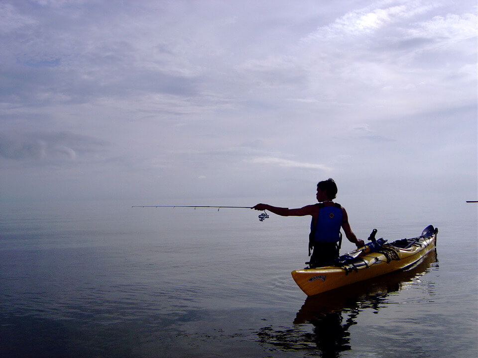A lonely fisher with his kayak.