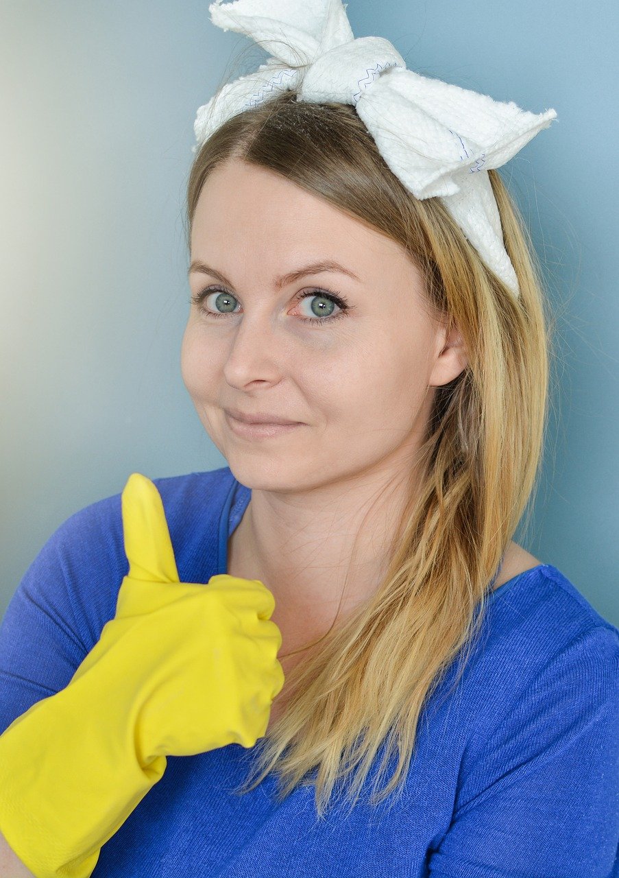 woman wearing a scarf and rubber gloves ready to clean