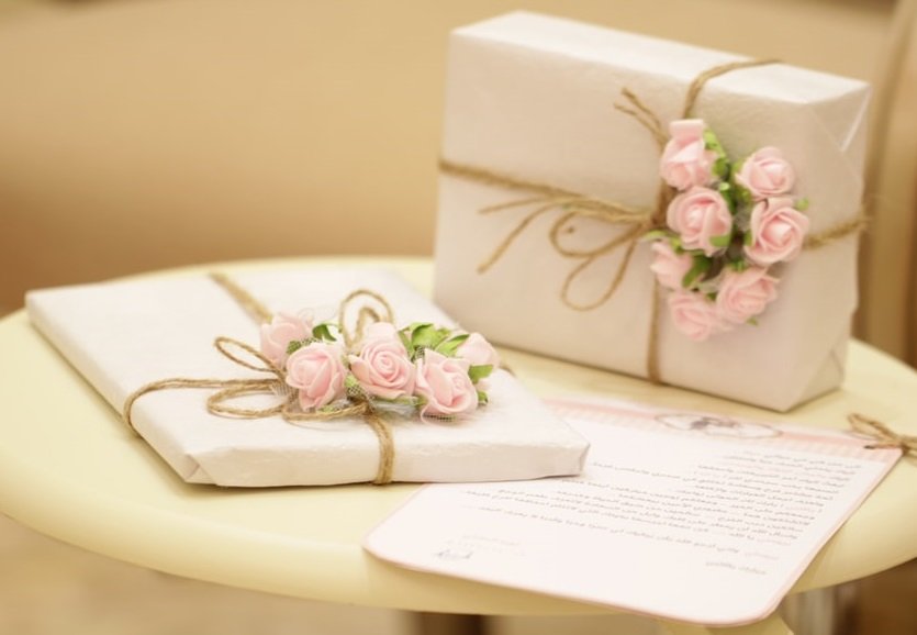 elegant pretty white and pale pink wedding gifts on a table.