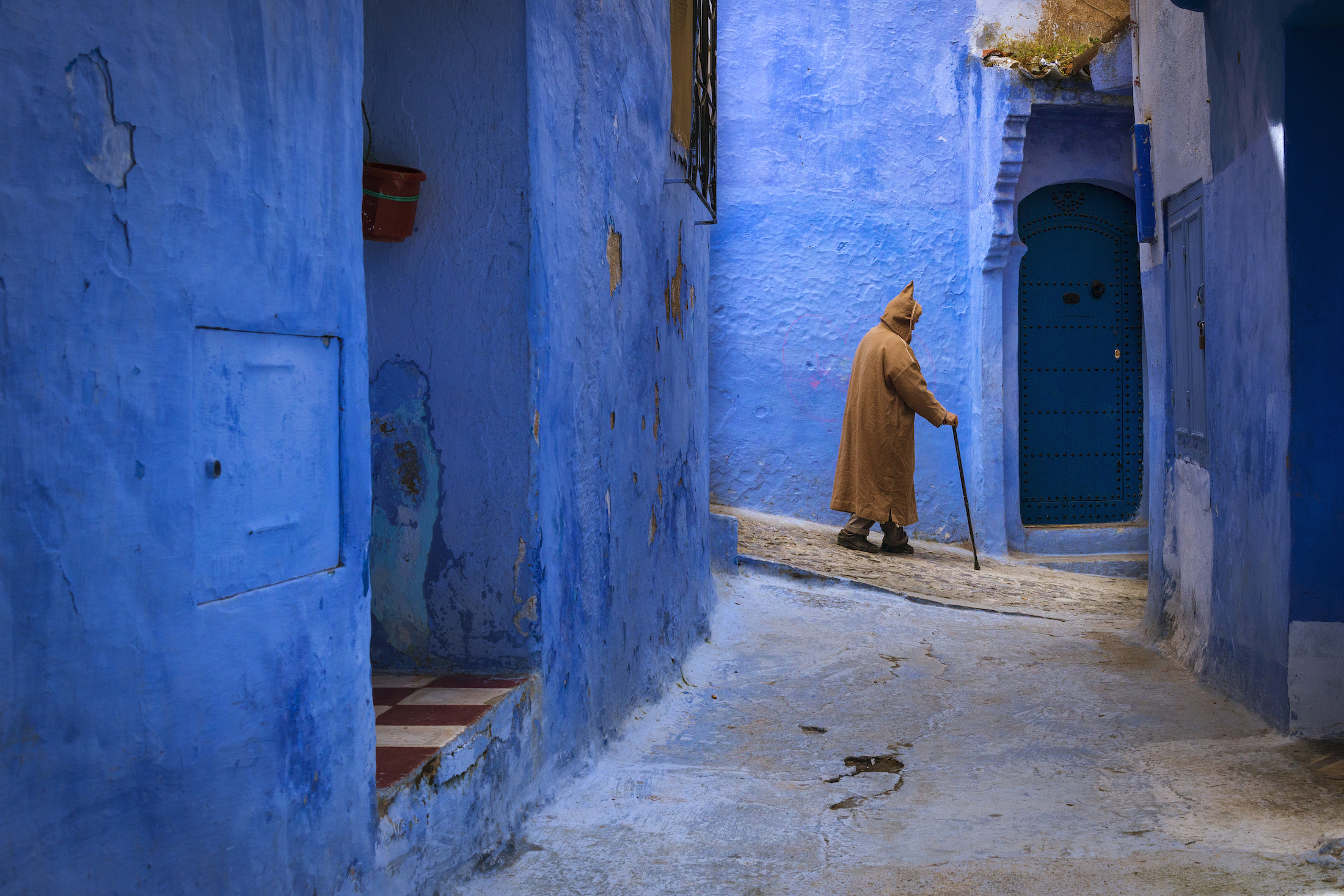 Berber man walking in a narrow street in the town of Chefchaouen in Morocco, North Africa