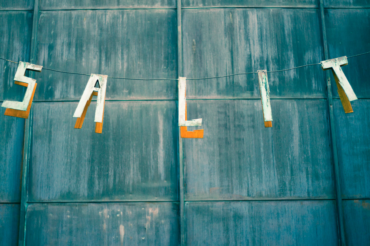 A split toned image of a washing line with the letters SALIT