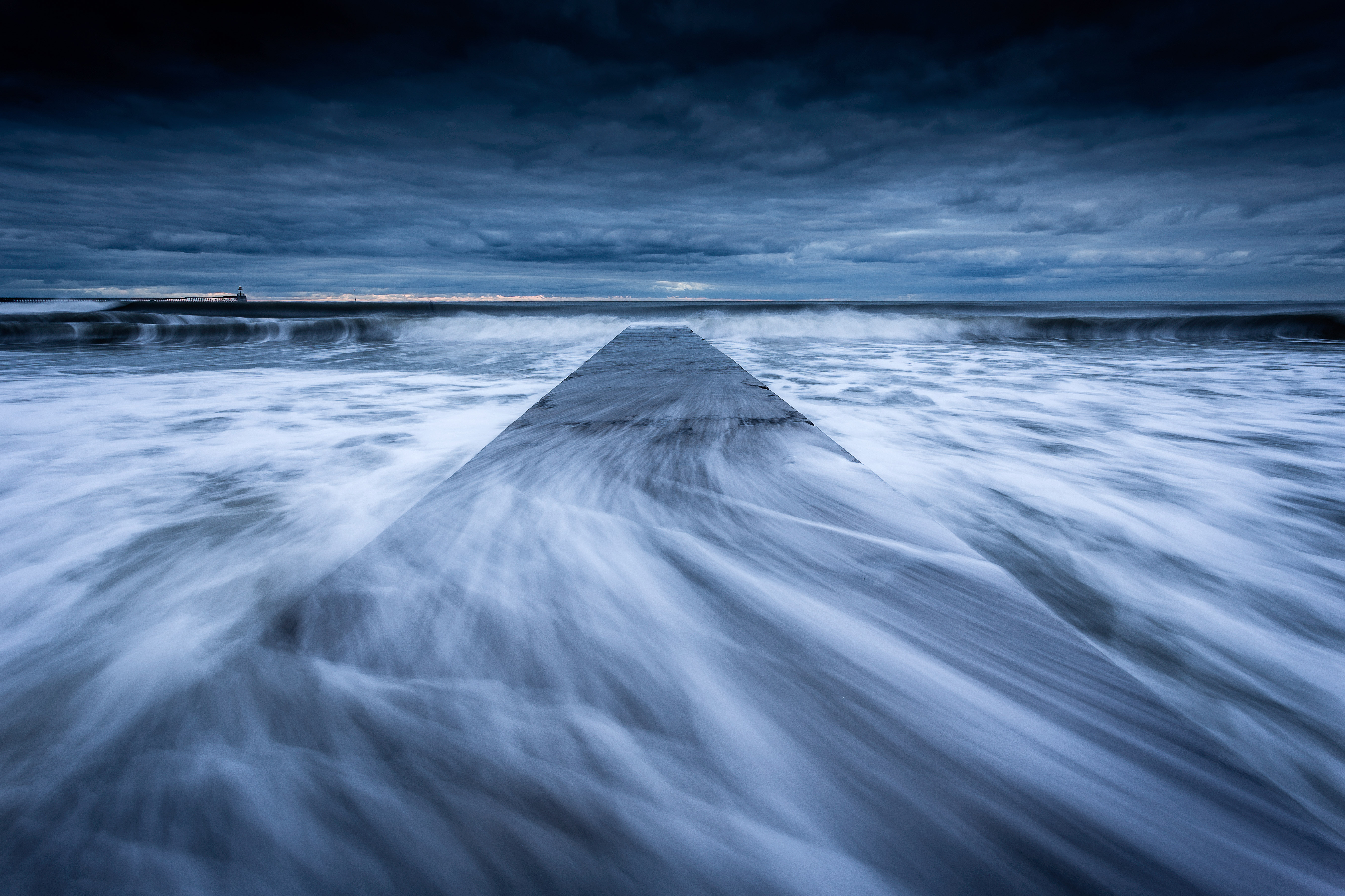 Waves sweep across the concrete jetty at Blyth Beach on the Northumberland coast.