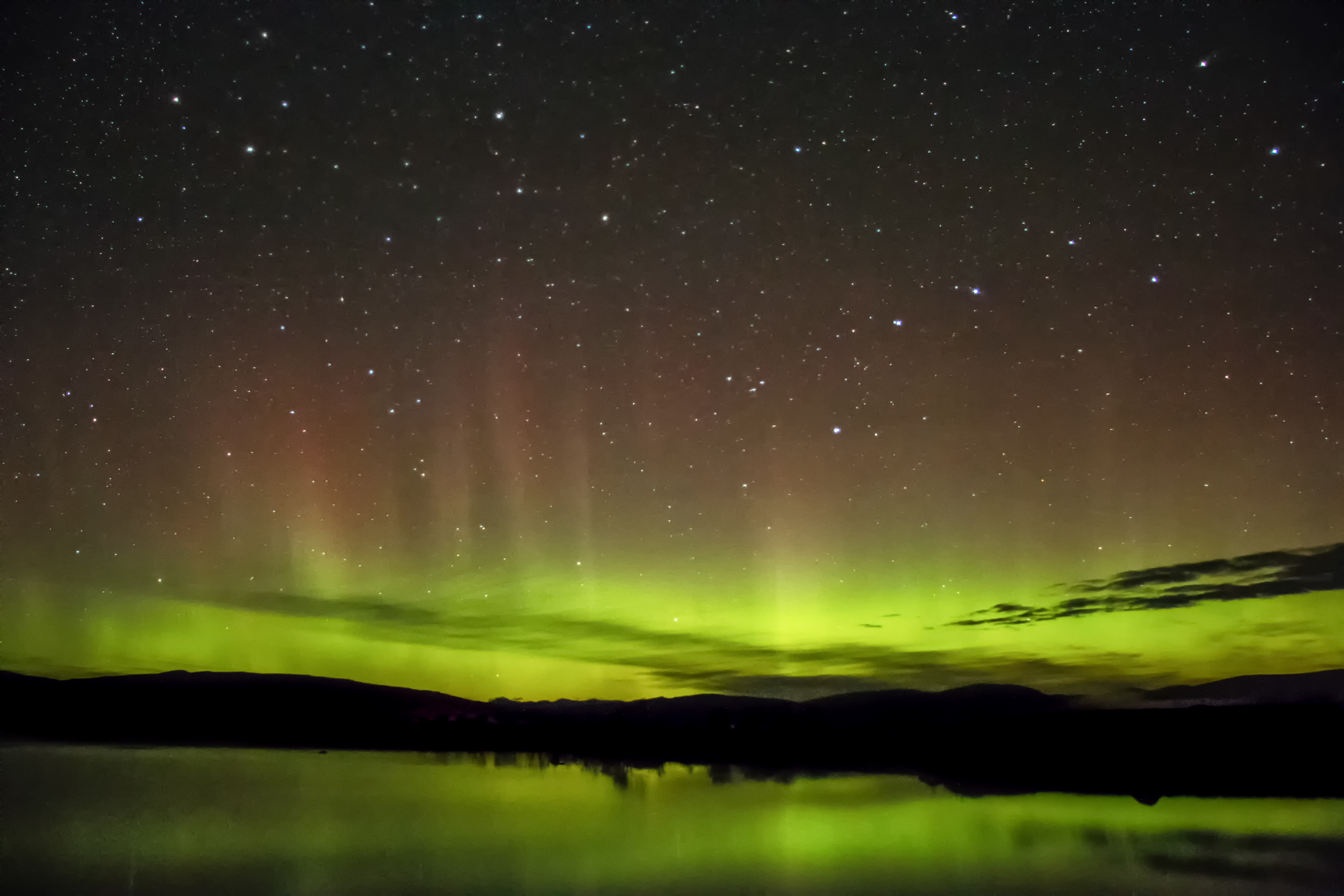A faint aurora over a loch in Scotland