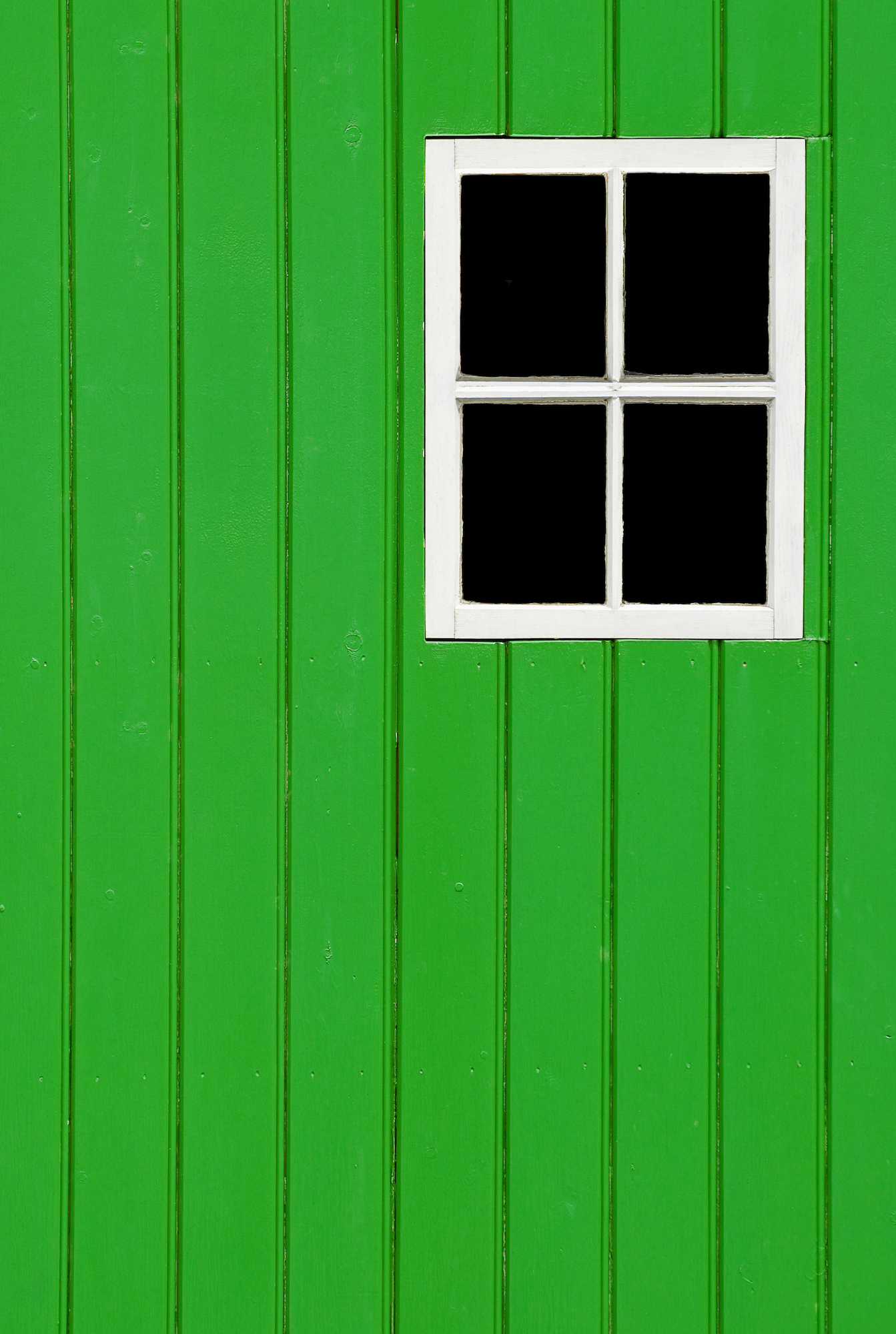 Building side view of a green wood panel frame with blank windows