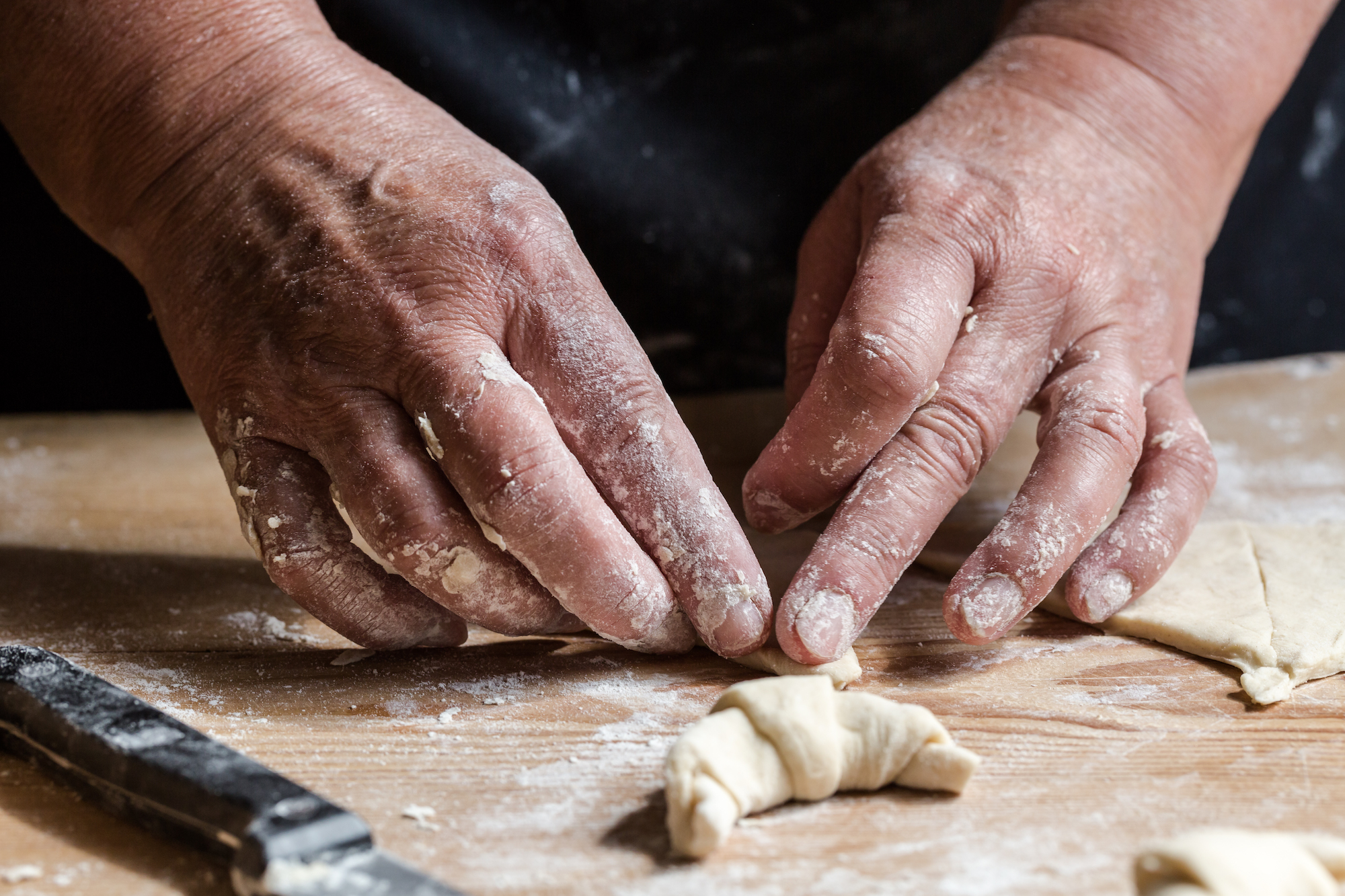 Hands rolling fresh homemade croissants