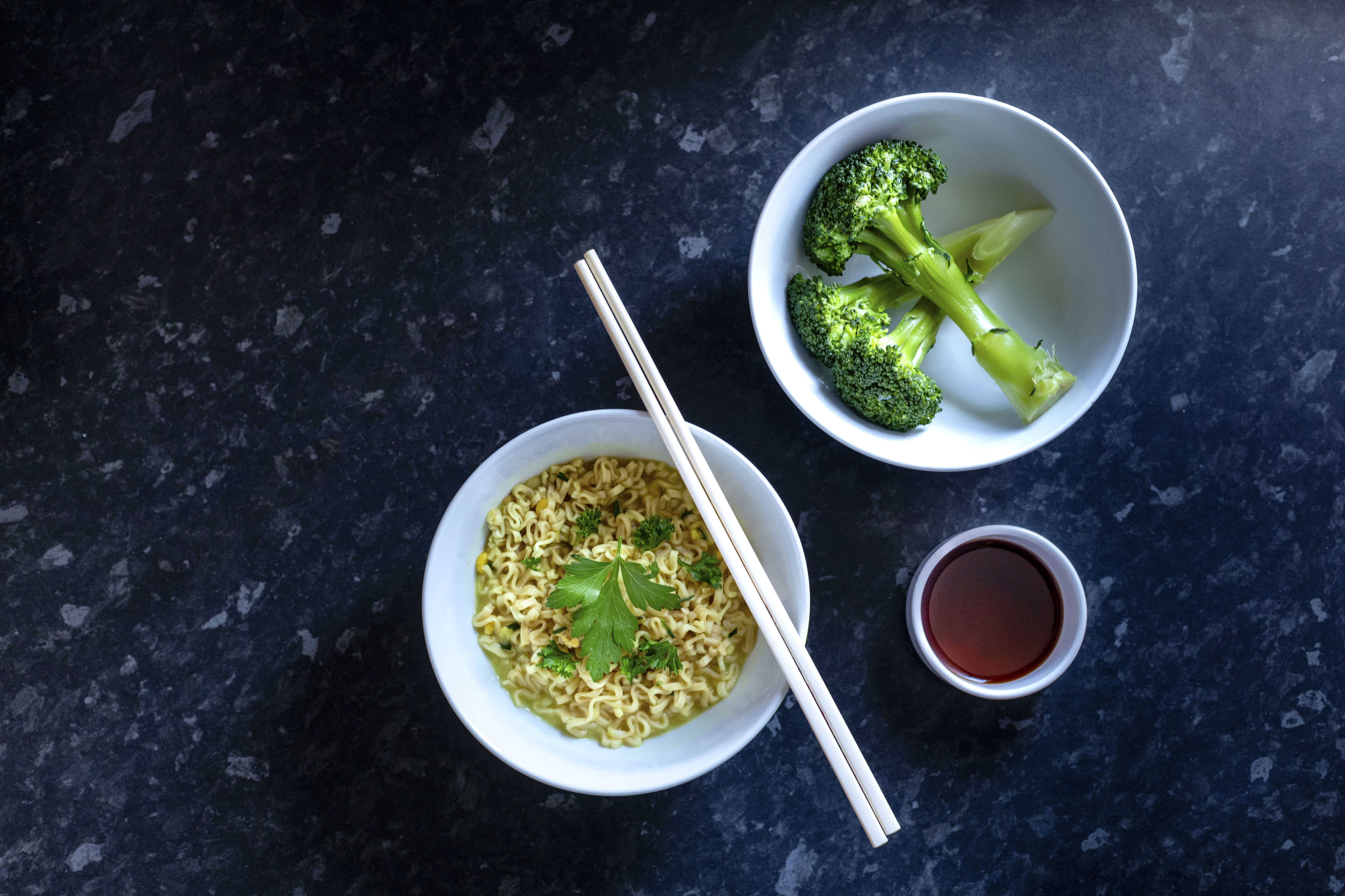 Overhead view of noodles, broccoli and chopsticks
