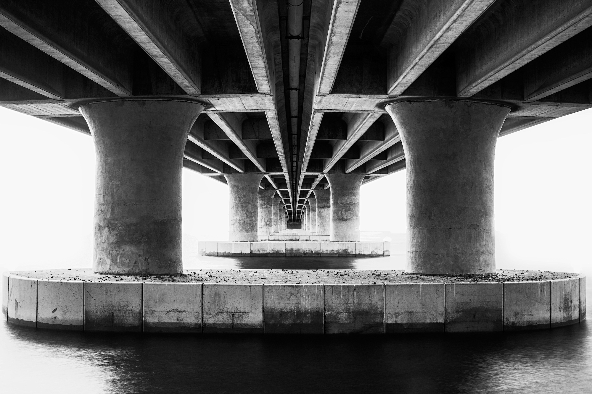 Concrete convergence photographed from underneath a bridge