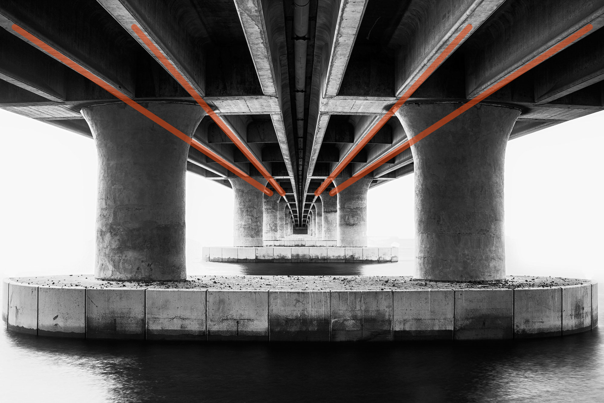 Concrete convergence photographed from underneath a bridge, with added leading lines to show the compositional technique