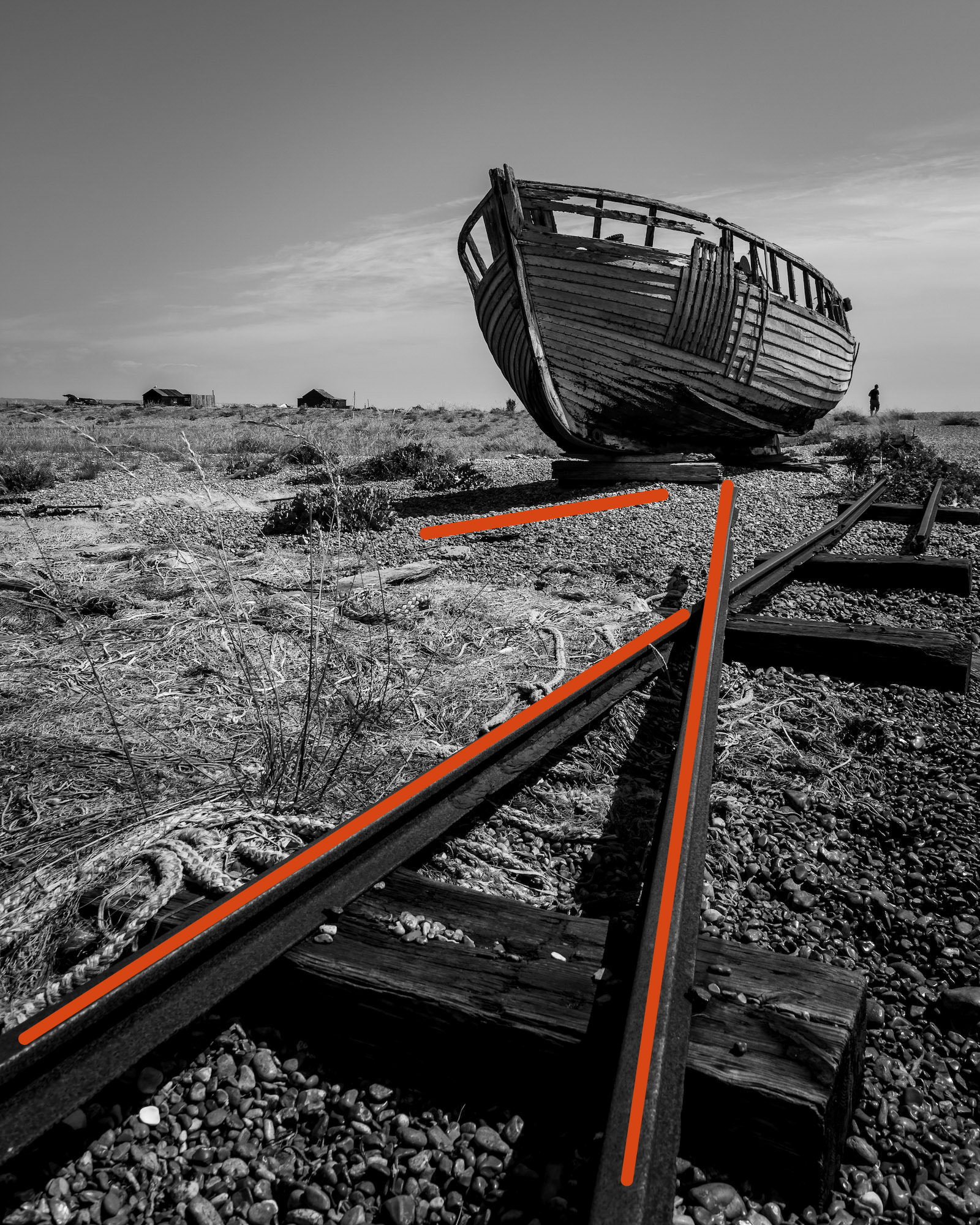 One of the many fishing boats left to rot on the beaches at Dungeness, with added leading lines to show compositional technique