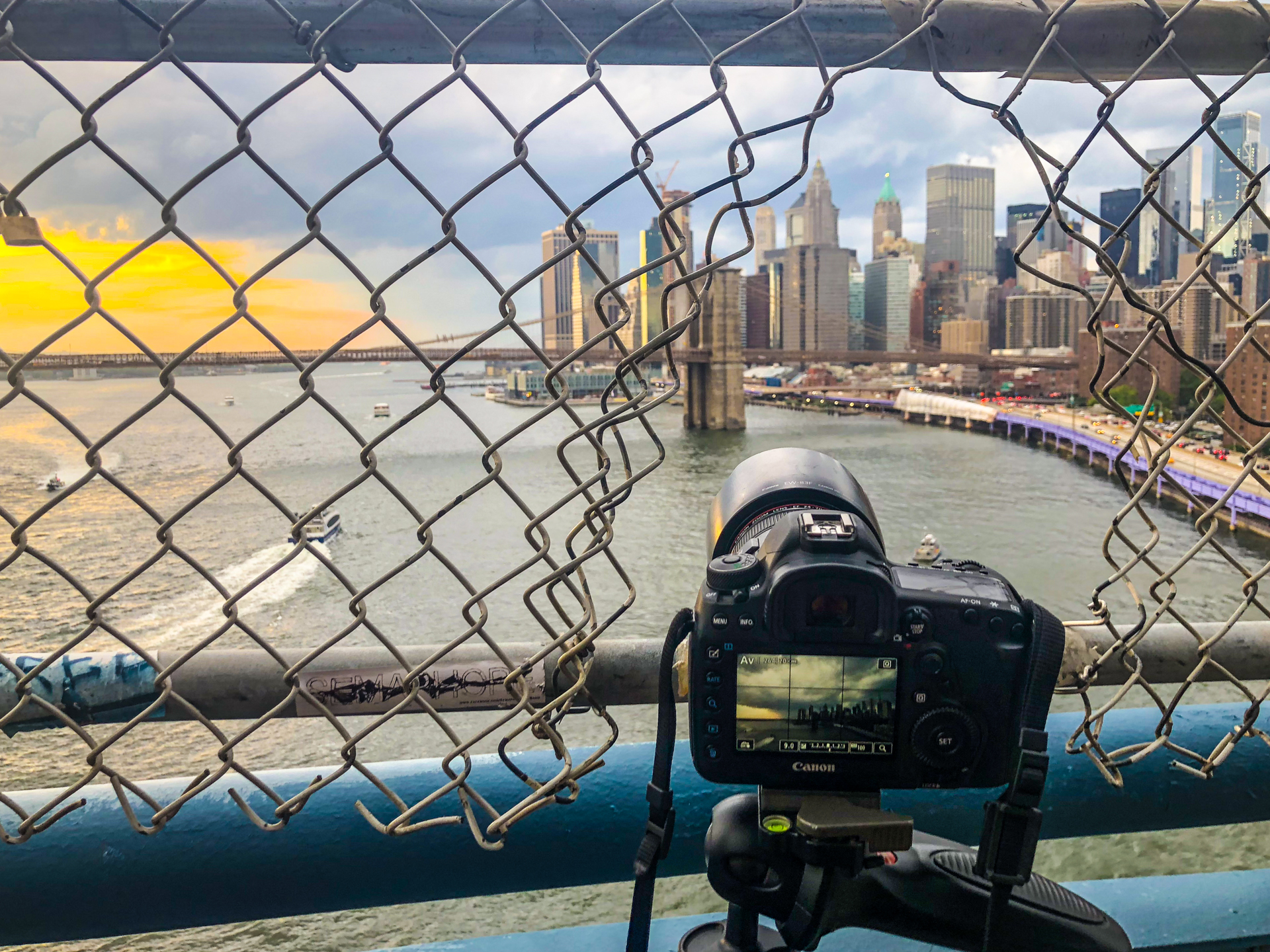 A camera mounted on a tripod looking toward Lower Manhattan