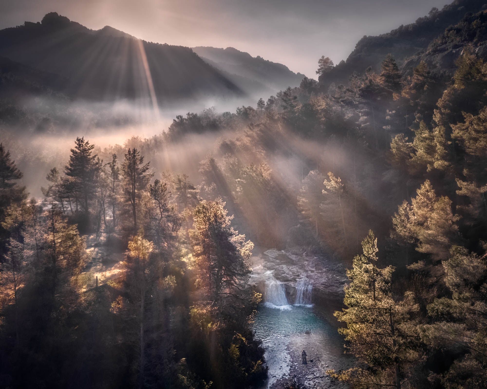 Photo taken by drone of a waterfall in a foggy forest
