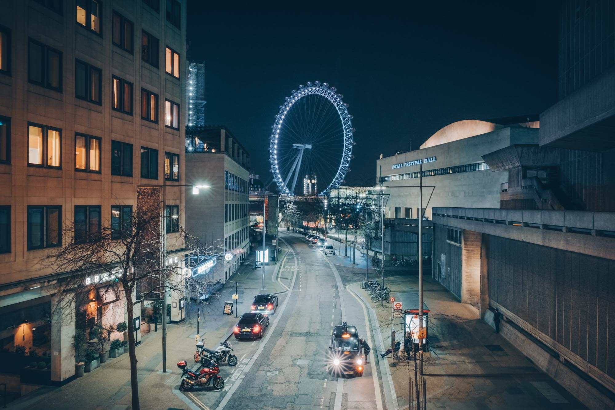 A taxi driver picking up in London while the London Eye shines bright in the background