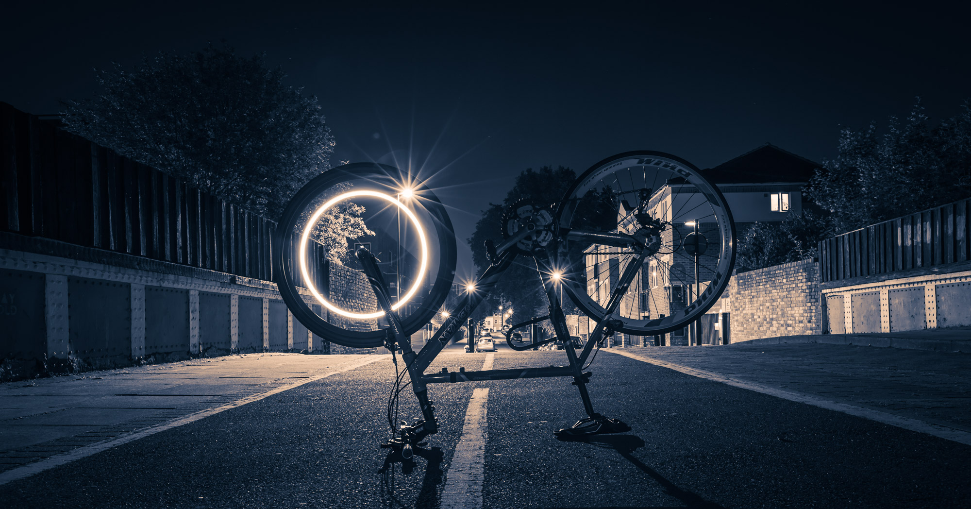 Long exposure of a light trail on the front wheel of a bike