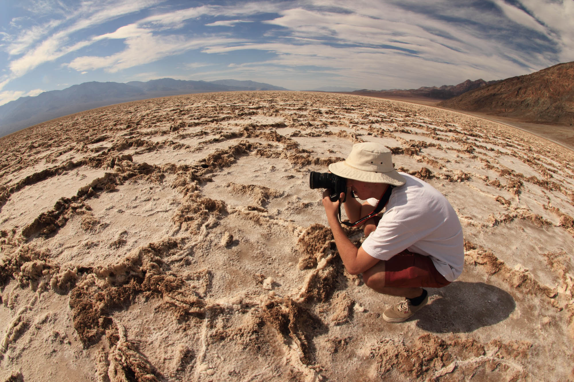 A photographer at Bad Water in Death Valley desert USA