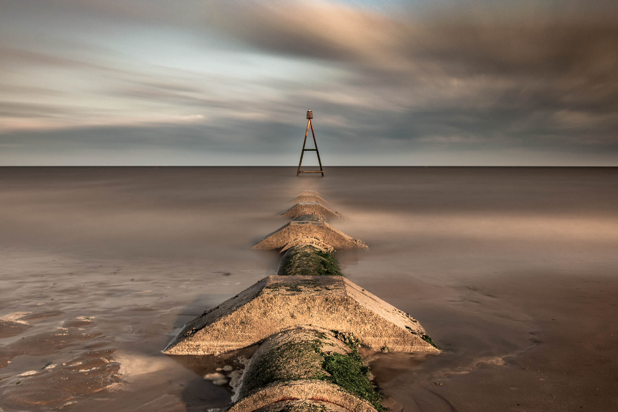 An early morning photo of a waste pipe heading out to sea at Hunstanton, England.