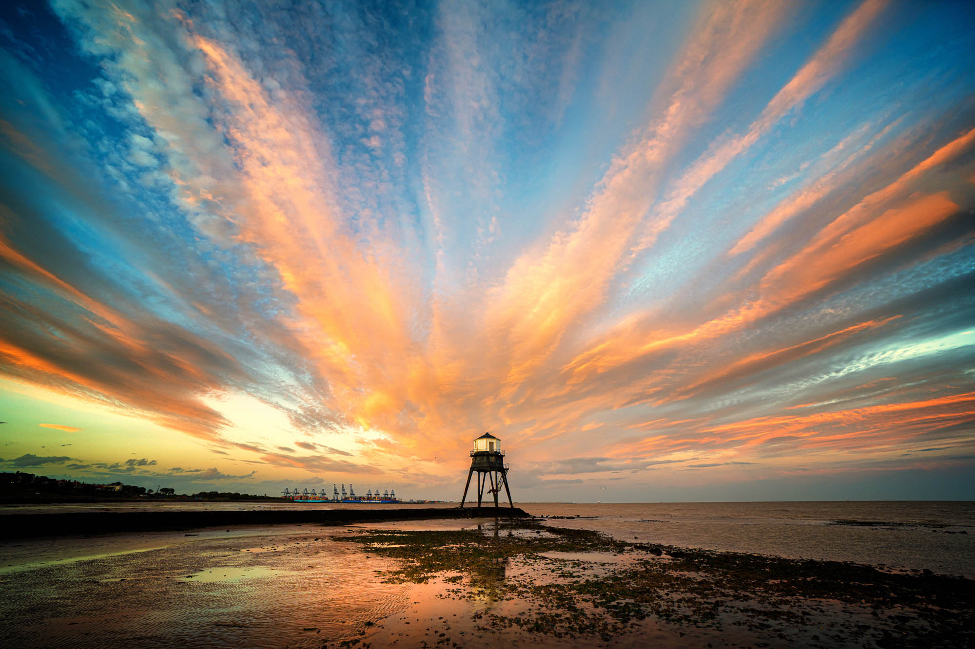 View of sunset through there passing clouds heading inwards towards the Dovercourt Low Light in Essex in August 2020