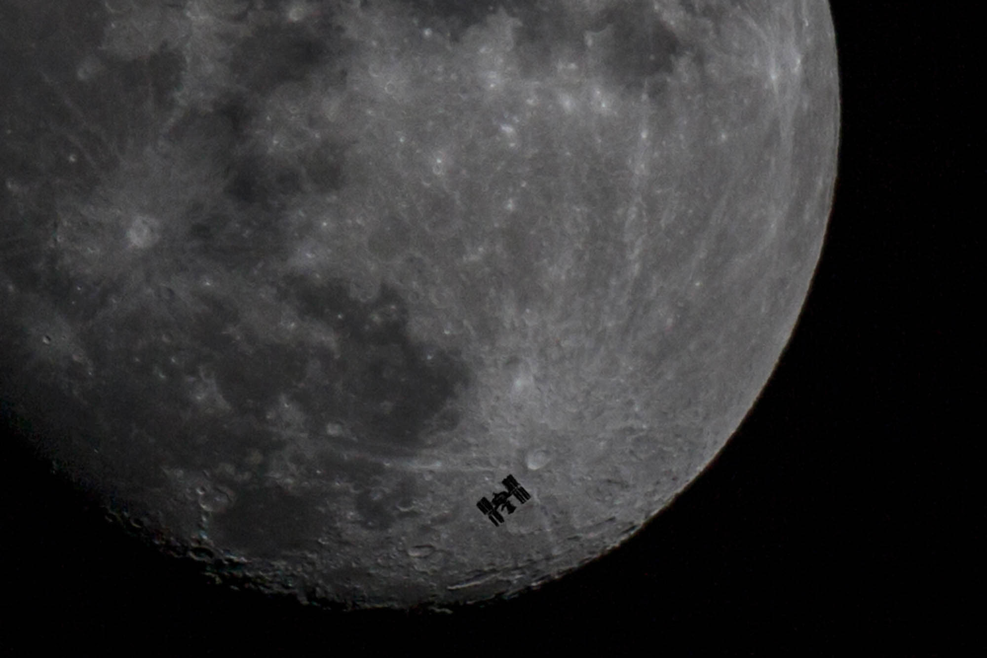 The International Space Station passing between the Moon and Earth, 260 miles in the sky.