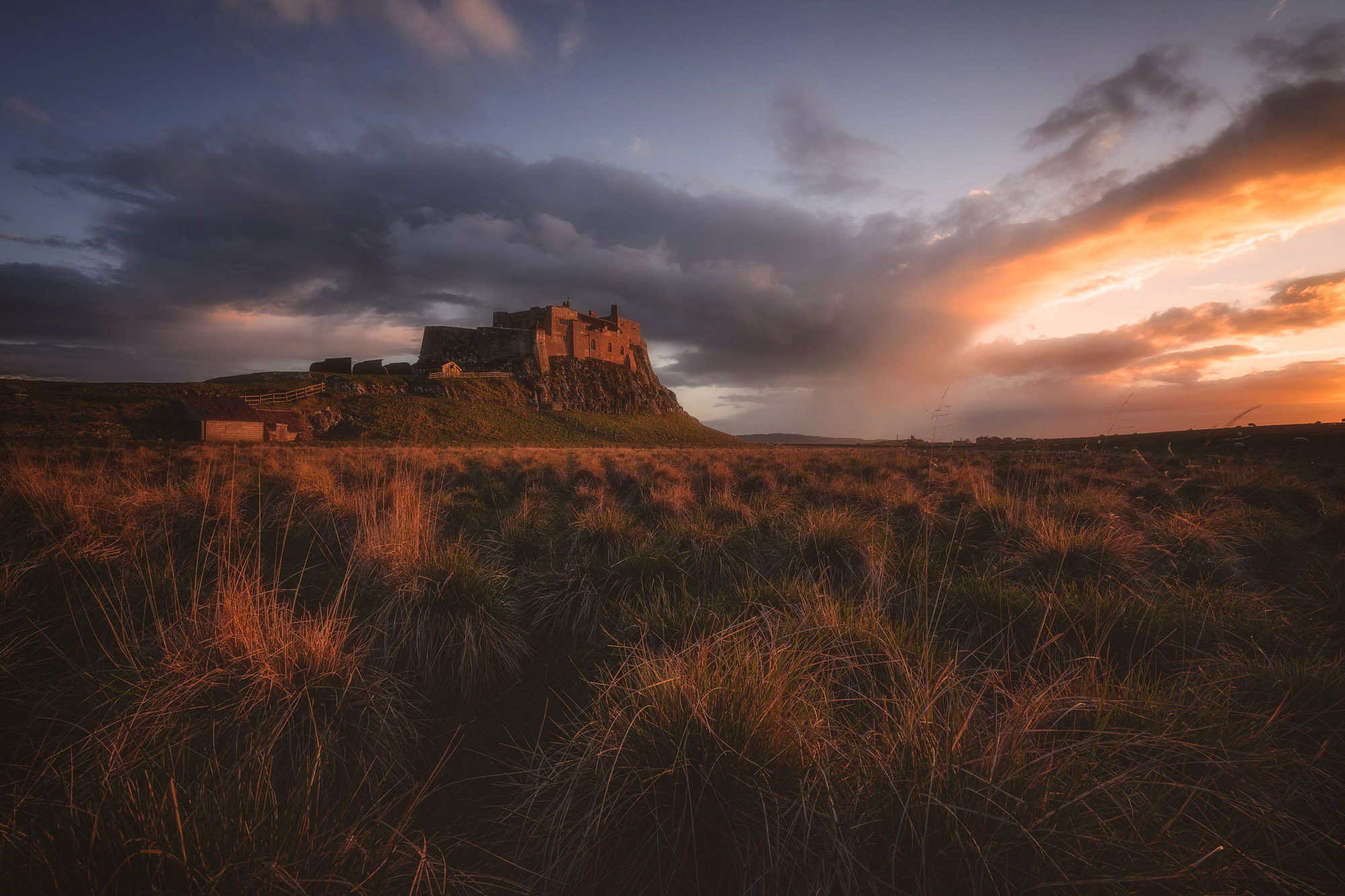 A dramatic orange sunset was created over Lindisfarne Castle after been subject to a dark and moody storm. Soft golden light decorates the castle and the grounds illuminating every fine detail.