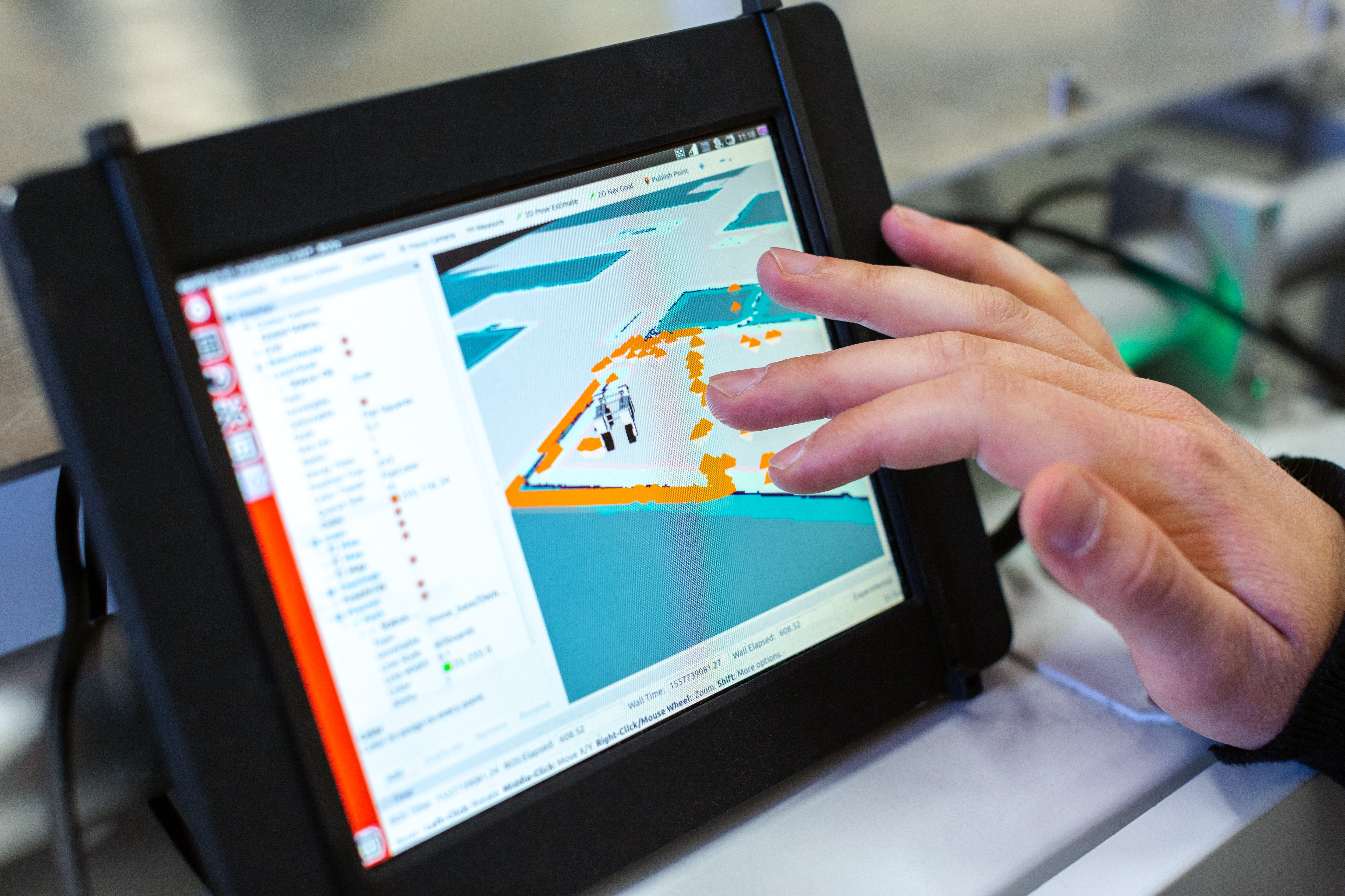 Hand touching a schematic diagram on an electronic tablet.