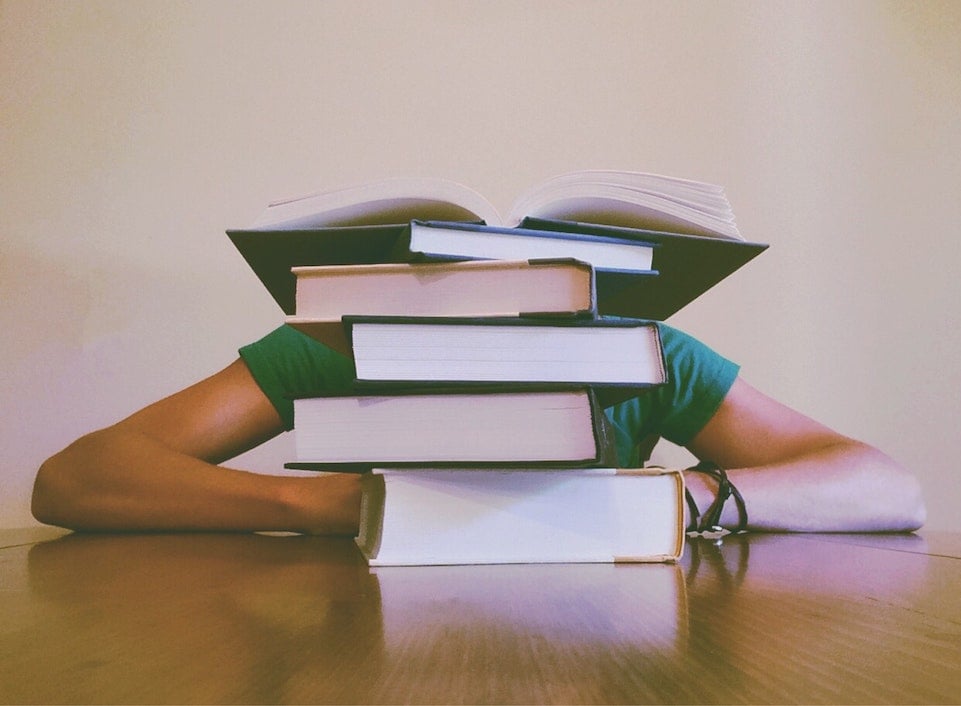 person behind a stack of textbooks