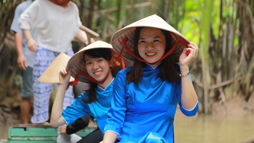 nữ hướng dẫn viên du lịch Nón Lá mỉm cười trên chiếc thuyền nhỏ
