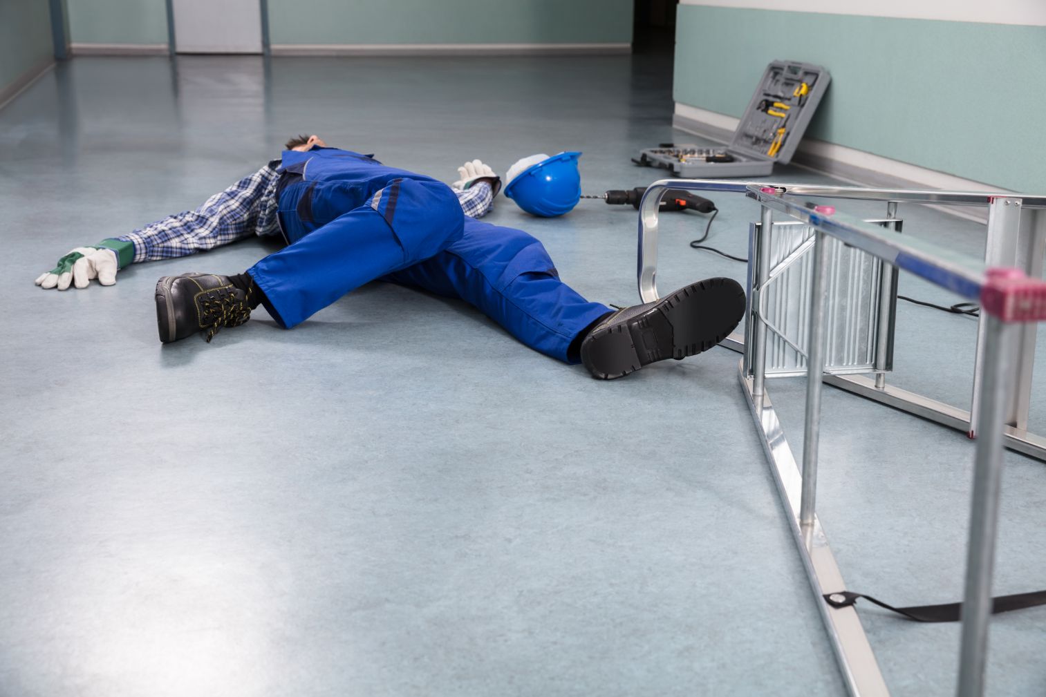 Trabajador en el piso después de caerse de una escalera.