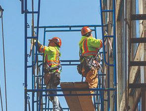 Trabajadores de construccion en un andamio.