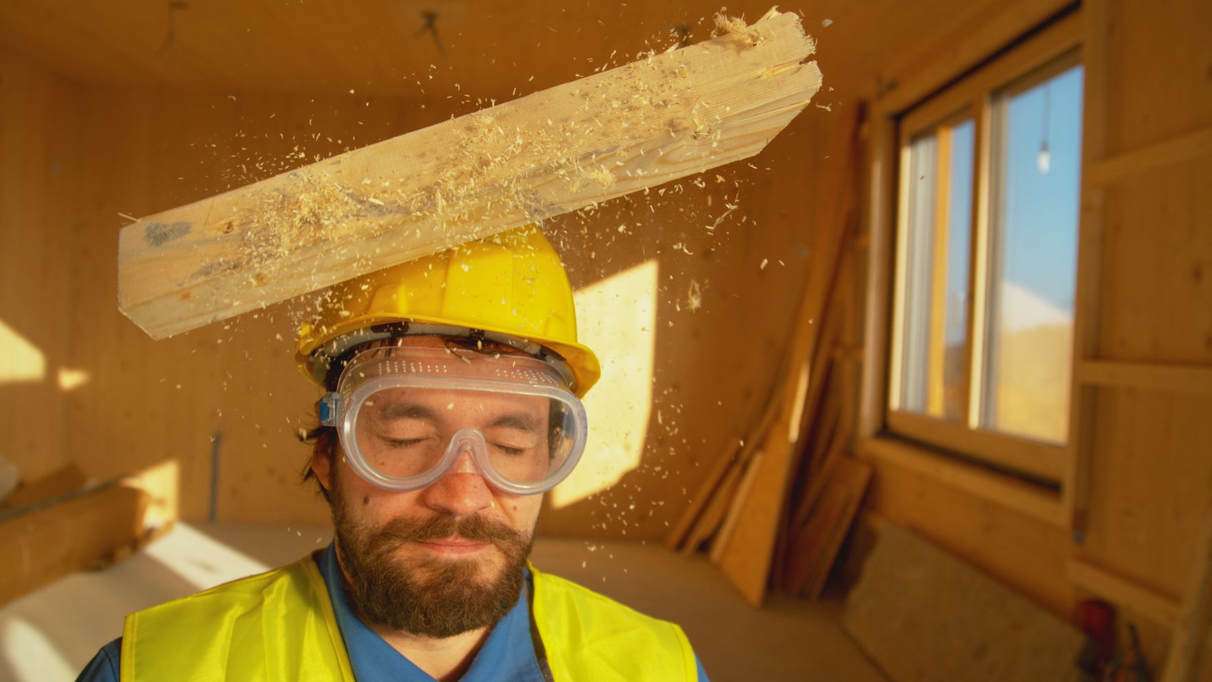 Madera cayendo en casco de seguridad de trabajador de construcción.