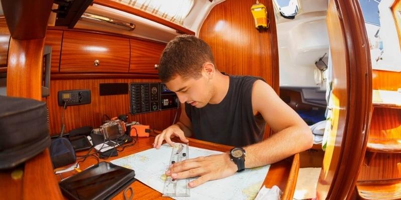 guy plotting a route below deck