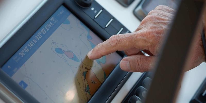 hand pointing at chartplotter