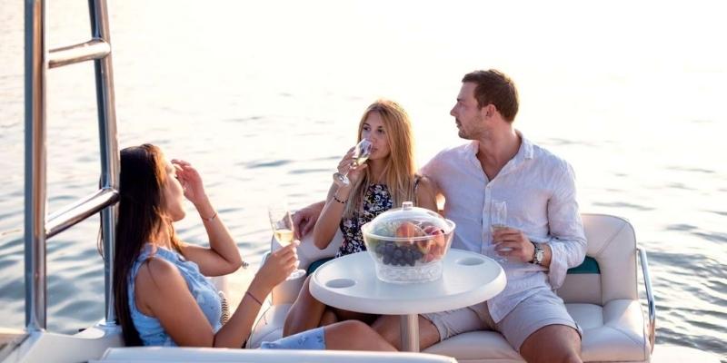 two women and a man drinking champagne on a boat